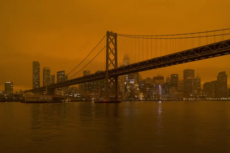 Bay Bridge and the San Francisco skyline under a dark orange wildfire-smoke sky in September 2020